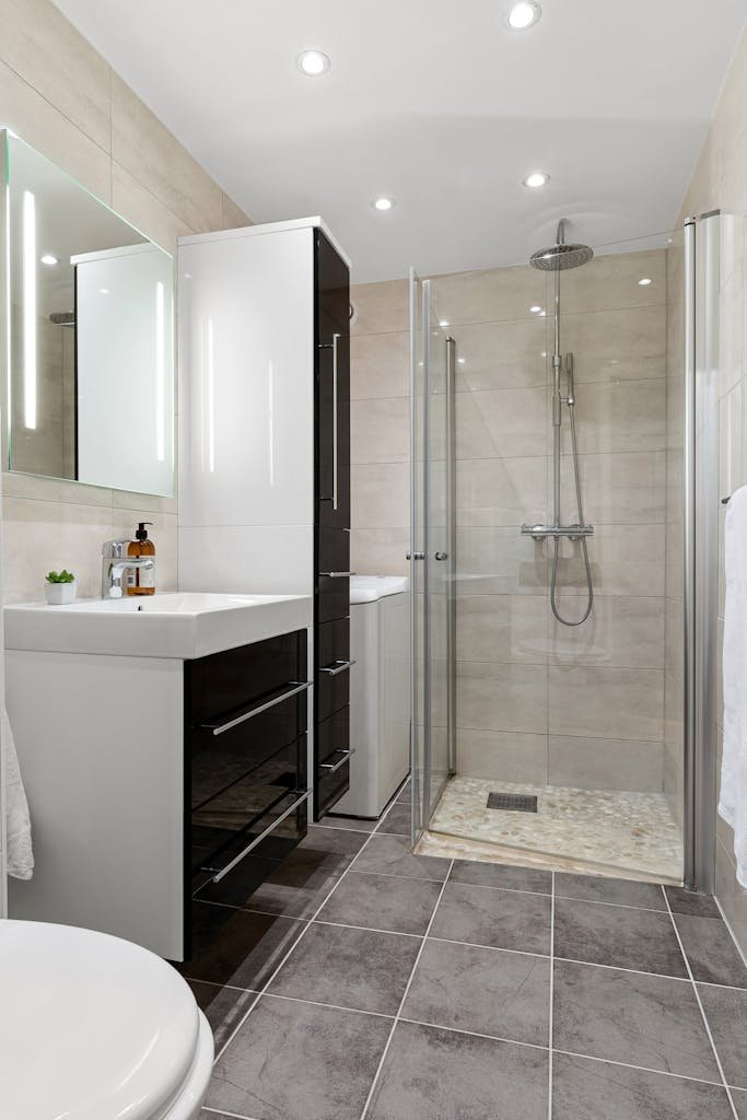 Photo by Alex Tyson Contemporary bathroom interior featuring sleek glass shower and elegant fixtures.